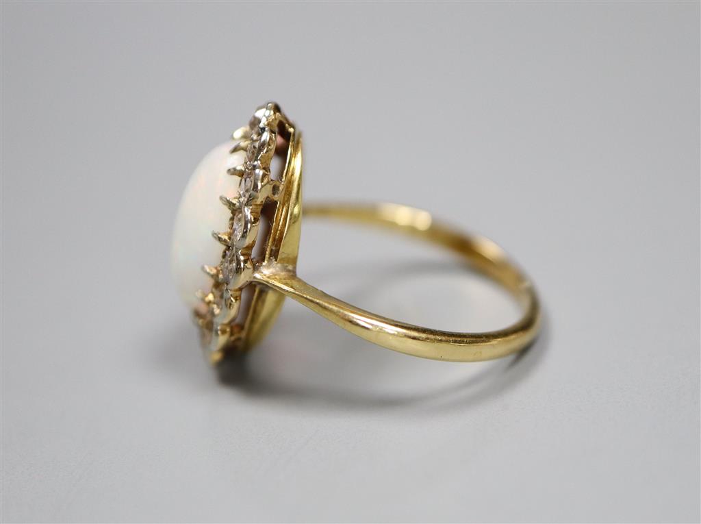 An early to mid 20th century 18ct, white opal and diamond set oval cluster ring, size K, gross 3.1 grams.